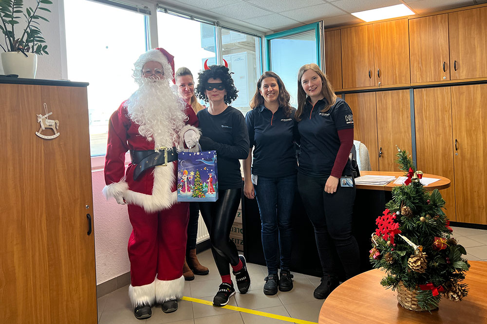 Santa Claus posing in office with four employees