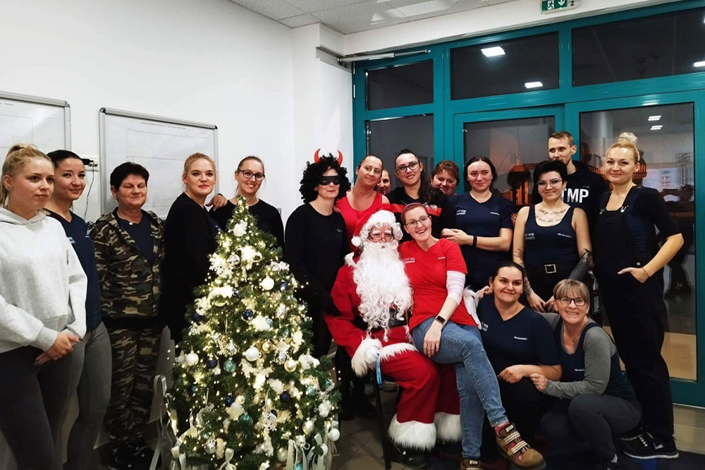 Employees group picture with Santa Claus and Christmas tree