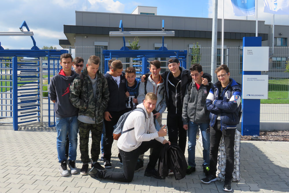 Group photo of schoolchildren being shown around the Freudenberg factory
