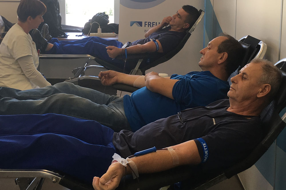 A sitting nurse and three Freudenberg Kecskemét employees donating blood