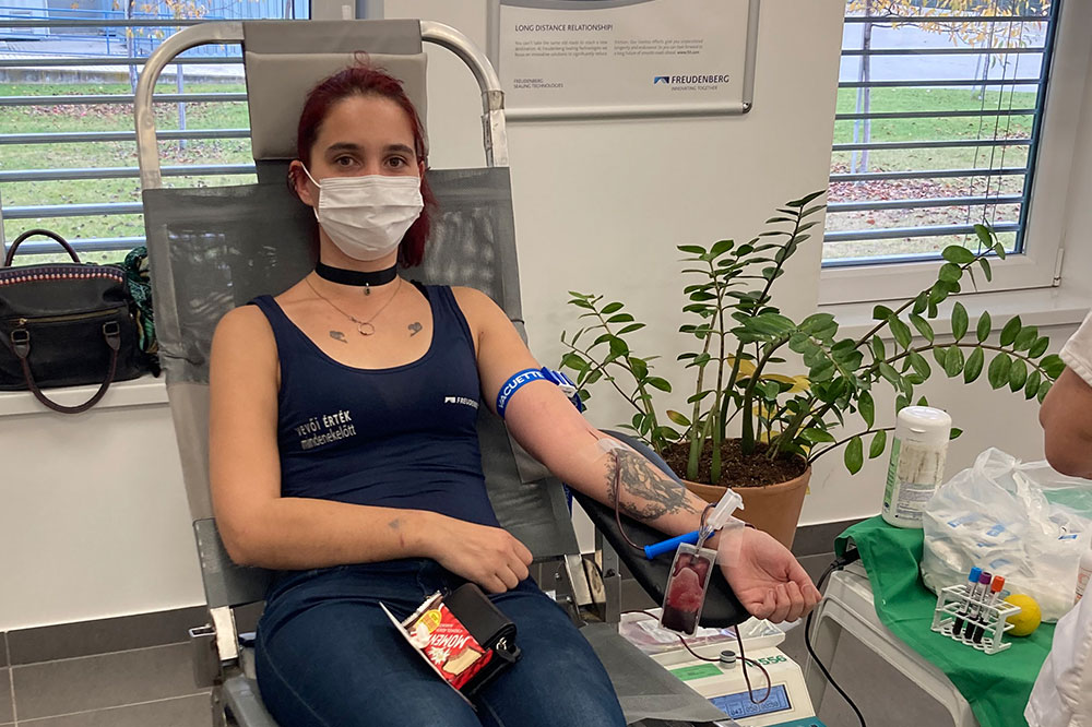 Employee with mask over mouth donates blood