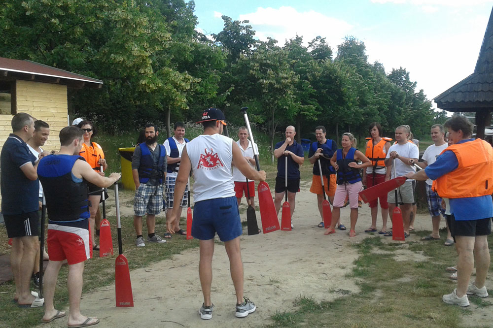 Employees stand in a circle and prepare for canoe trip