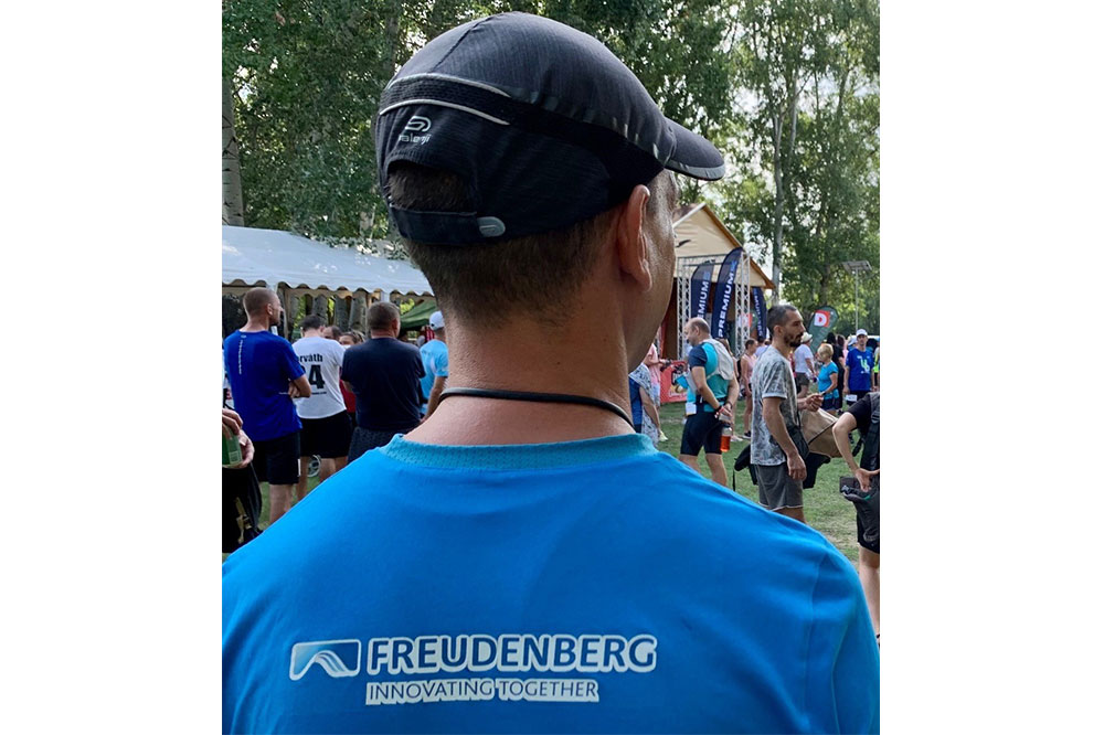FST employee shows Freudenberg jersey from behind at a sporting event