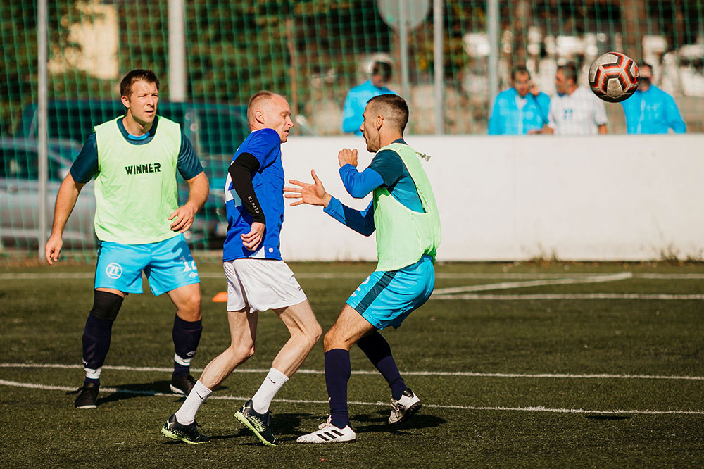 Tense situation between three soccer players in the middle of the game