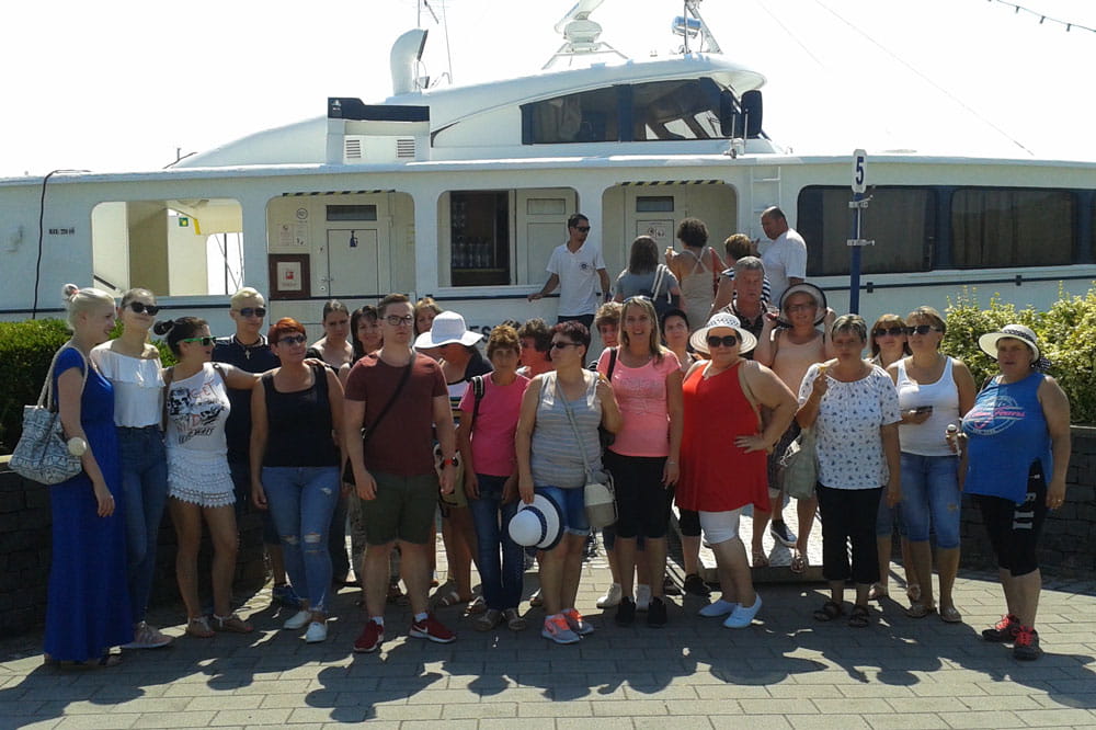 Group photo of employees standing in front of a steamer