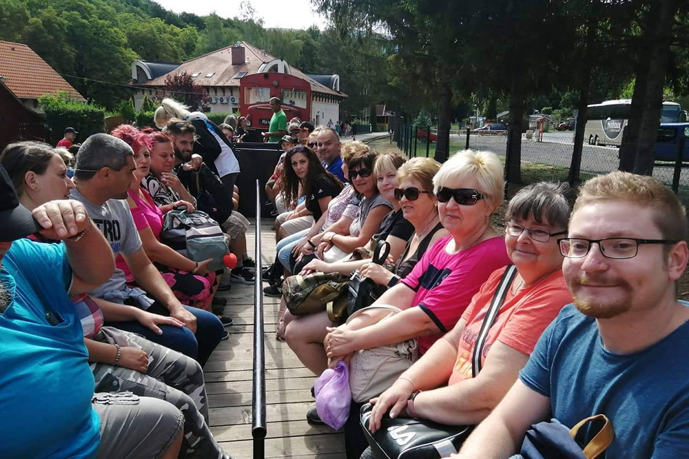 Employees sit in an open tourist train