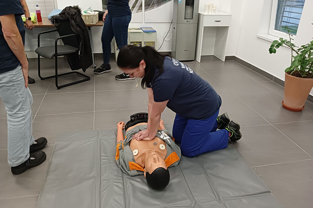 An employee practising first aid on a training dummy