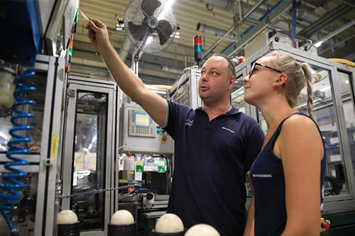 János Seres shows another employee a machine